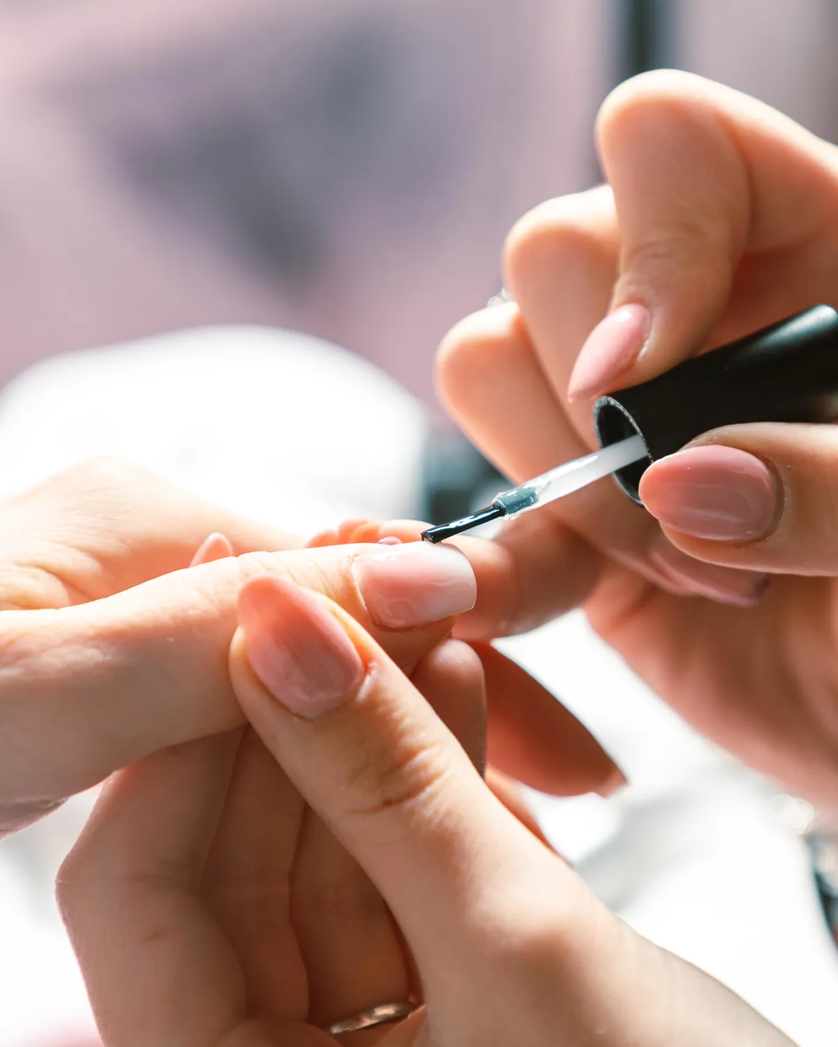 Pose d’un vernis nude, gros plan sur les mains